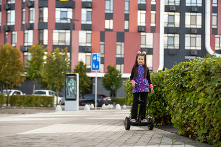 A little girl riding a electric scooter. Personal eco transport, gyro scooter, smart balance wheel....