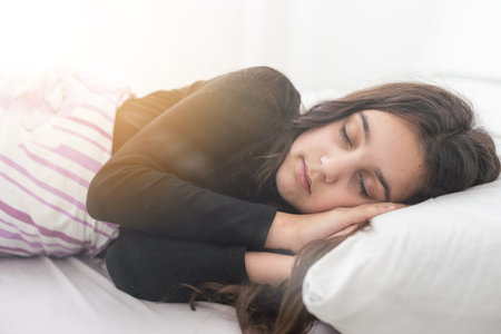 Teenager child girl daydreaming in bed, dreaming kids concept. Happy teen girl, positive and smiling emotions.の写真素材