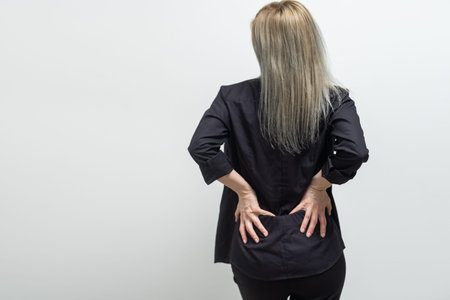 Back Pain. Woman rubbing muscles of her lower back. Sports exercising injury.