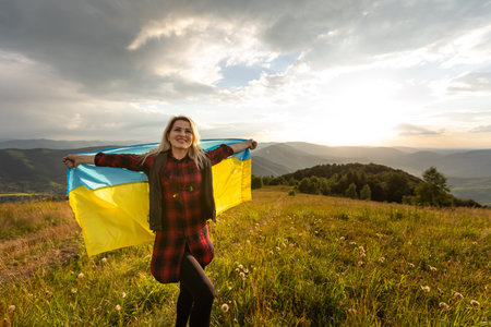 Woman holding a yellow and blue flag of Ukraine in outdoors. Independence Day. Flag Day....