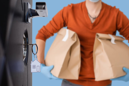A food delivery man in front of the open door of the apartment
