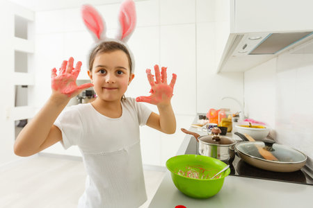 a little girl makes colored dough with her hands