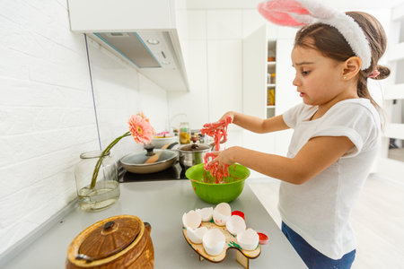 a little girl makes colored dough with her handsの写真素材