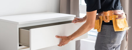 Young male worker repairing furniture