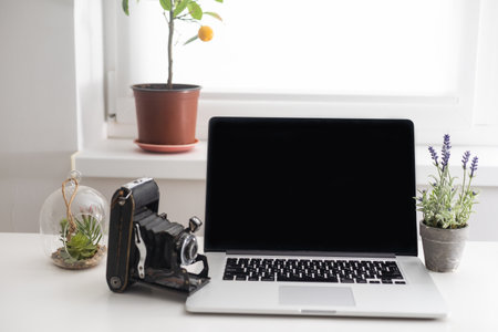 portable office desk with mock-up computer devices, supplies and decorations on white tableの写真素材