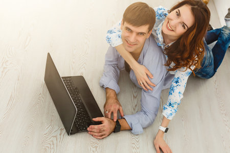 Couple buying online together with a laptop on a desktop at homeの写真素材