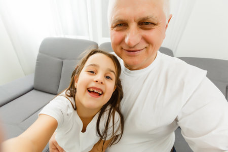 The happy girl and a grandfather making a selfieの写真素材