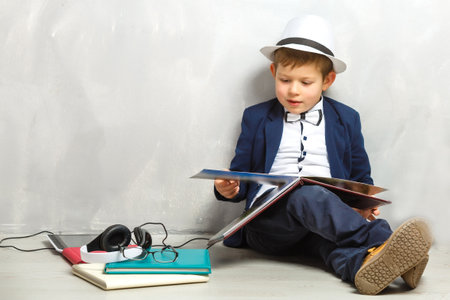 Happy curious kid little boy genius on gray backgroundの写真素材