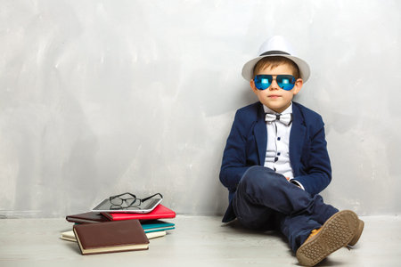 Elementary school student carrying notebooks over a gray background