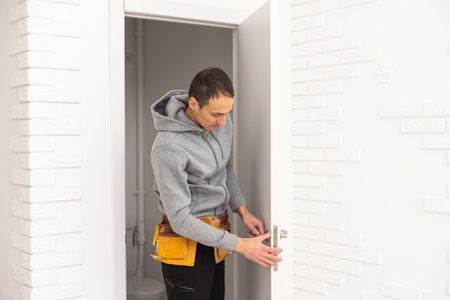 male workers carpenters installing interior door with a wooden frame at new luxury apartmentの写真素材