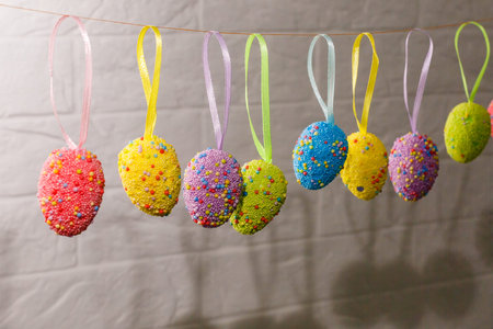 Colorful easter eggs hanging on silk ribbons with bows isolated