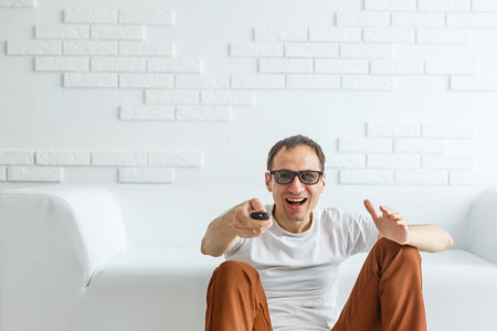Mature Man Sitting On Couch Watching Television