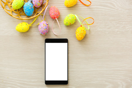 phone mockup with plants. invitation card with environment and quail eggs. easter eggs, ribbons and...