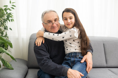 Little granddaughter hugging her grandfatherの写真素材