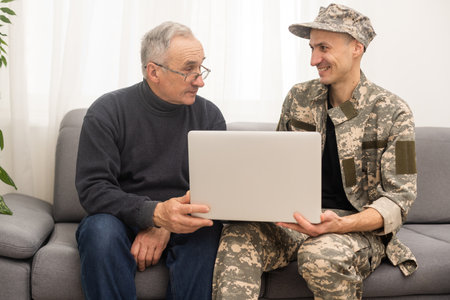 Portrait of army man with parents, elderly father and military son.の写真素材