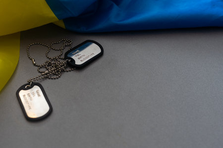 military ID tag and Ukrainian flag on background. Banner designの写真素材