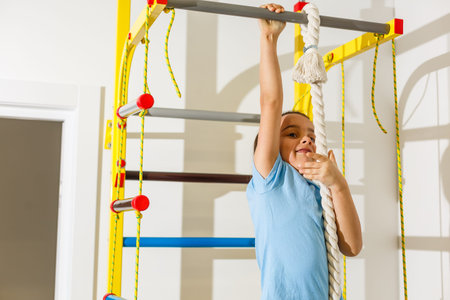 Beautiful athletic girl plays sports on Wall bars in the childrens room