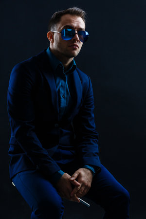 businessmen modern style suit fashion sunglasses dark background.の写真素材