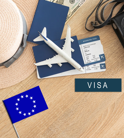 Flag of European Union with passport and toy airplane on wooden background. Flight travel conceptの写真素材