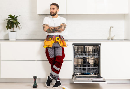 Technician or plumber repairing the dishwasher in a householdの写真素材