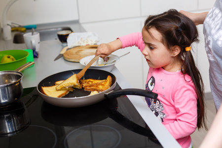 Mother and daughter in kitchen cooking.の写真素材