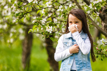 Girl is blowing her nose, allergic to bloom flowersの写真素材