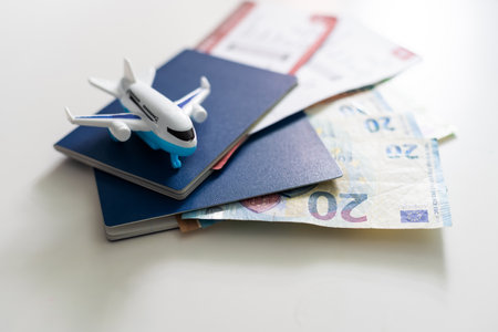 Passports, boarding passes and toy airplane on white tableの写真素材