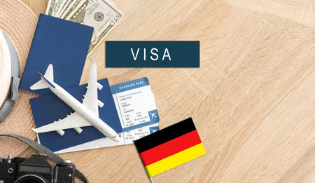 Flag of Germany with passport and toy airplane on wooden background. Flight travel concept.の写真素材
