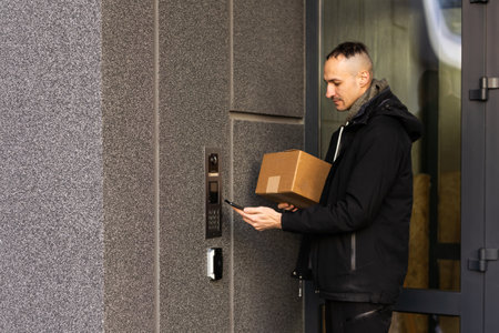 Man uses smartphone to open the door of his houseの写真素材