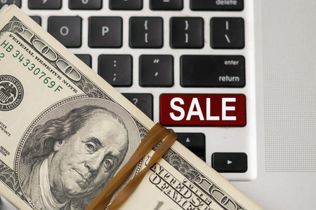sell written on keyboard showing business or finance conceptの写真素材