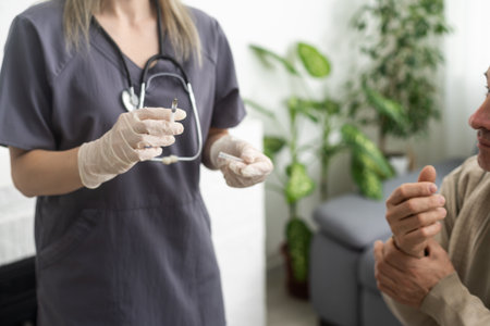 Antivirus vaccination for older people. Covid-19, pneumonia or flu preventive measures. Male senior citizen waiting to receive his vaccine. Asian doctor in face mask administering shot to mature man.の写真素材