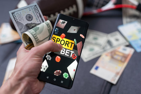 Smartphone with gambling mobile application, ball and money banknotes. Sport and betting conceptの写真素材