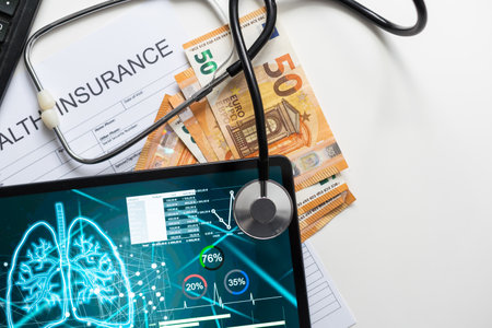 Modern social health insurance program. Tablet computer with healthcare application interface on screen. Stethoscope, x-ray image and cardiogram on wooden desk. Digital healthcare technologies.の写真素材
