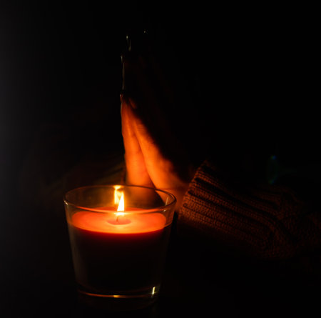 The candle is lit in a glass held by a beautiful woman in black. Isolated on the concept of saving the earths energy. Earth hourの写真素材
