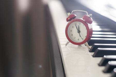Alarm clock on piano background. Music lessonの写真素材