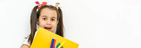Portrait of smiling school girl child with backpack and books isolated on a white backgroundの写真素材