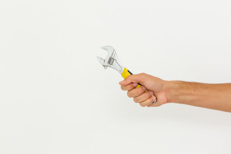 Partial view of man holding monkey wrench isolated on whiteの写真素材