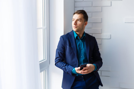 portrait of a young man standing by packages in empty officeの写真素材