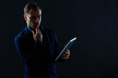 Happy smiling business man with crossed arms on black backgroundの写真素材