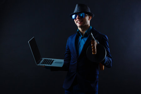 businessman in sunglasses with machine gun and laptopの写真素材