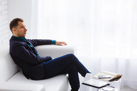 young businessman on a white sofa on white backgroundの写真素材