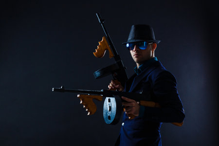 low key portrait of young gangster with hat in the darknessの写真素材