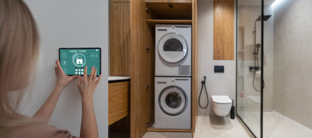 Controlling home with a digital touch screen panel installed on the wall in the living room. Concept of a smart home and mobile application for managing smart devices at home.の写真素材