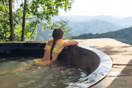 little girl in a hot tub in the mountains, summerの写真素材