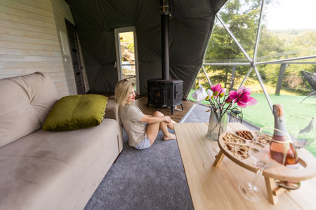 a woman enjoys solitude inside of a transparent bubble hotel.の写真素材