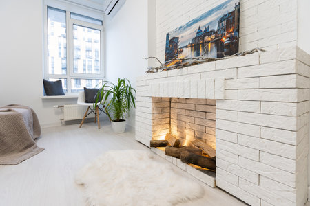Modern interior house with bright living room, fire in new fireplace, wall on backgroundの写真素材