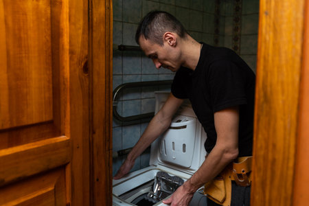 a worker and an old washing machineの写真素材