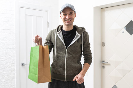 High angle portrait of handsome delivery man with cardboard box.の写真素材