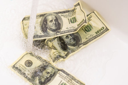 Money is thrown away in the sink. This photo concept illustrates the financial condition of a business that is failing or going bankrupt so that it only wastes money without resultsの写真素材