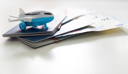 Passports, boarding passes and toy airplane on white tableの写真素材
